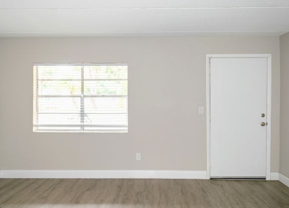a spacious living room with a large window in a Ridge Apartment home