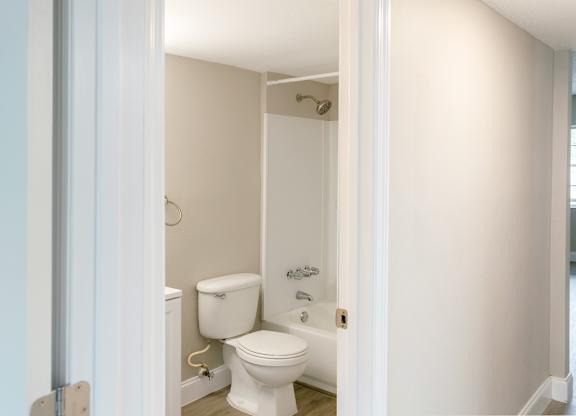a bathroom with a toilet, tub, and shower
