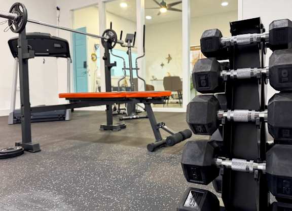 A fitness center with machines and a stack of free weights at Haven on Canal Apartments