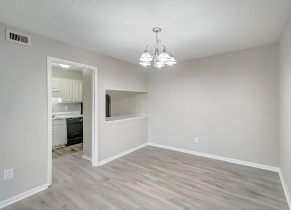 a dining room with wood-style flooring and modern chandelier at Hills at Hoover 35216