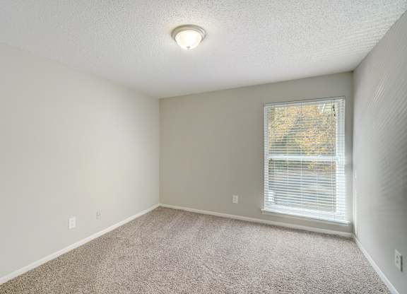 a bedroom with carpet, light, and a large window at Hills at Hoover 35216