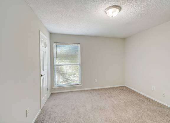 a bedroom with a ceiling light and large window at Hills at Hoover 35216