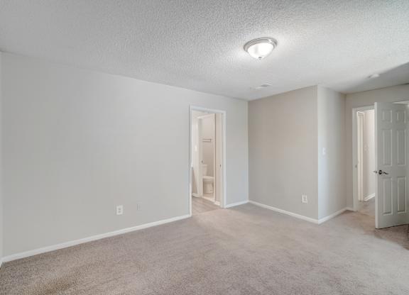 a spacious bedroom with bathroom access at Hills at Hoover 35216