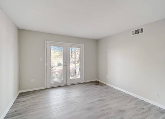 a living room with wood-style floors and french doors to a deck at Hills at Hoover 35216