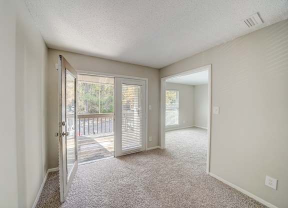 a spacious living room with french doors to a balcony at Hills at Hoover 35216