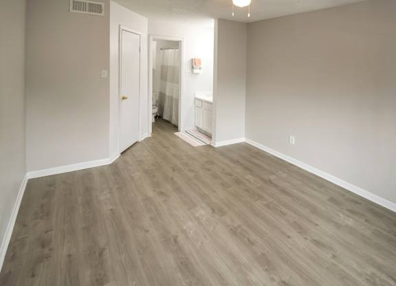 a spacious bedroom with wood-inspired flooring at Pine Creek Apartments