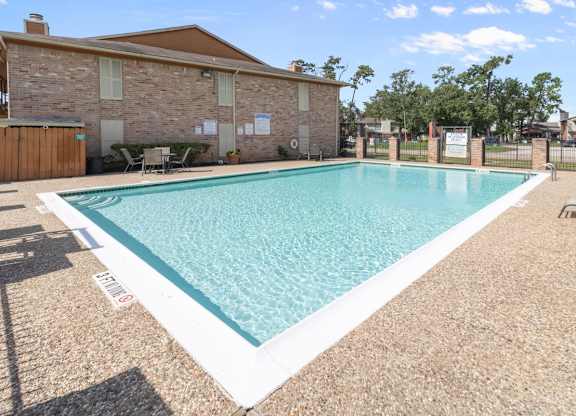The Forest Apartments in Houston features a sparkling pool and large sundeck with lounge chairs