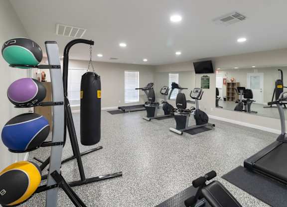 A gym with cardio equipment and weights at The Forest Apartments in Houston, TX