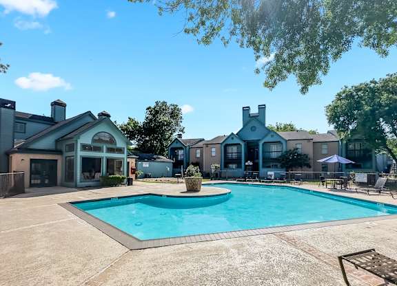 a sparkling blue pool and large sundeck with loungers at Waters at Westchase Apartments