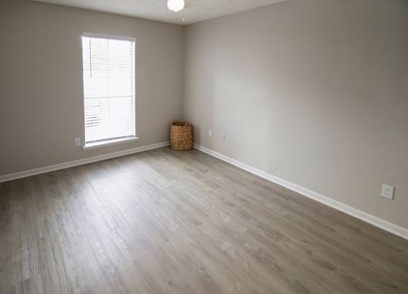 a spacious Pine Creek bedroom with a large window and illuminated ceiling fan