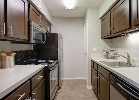 a kitchen with stainless steel appliances, built-in microwave, and wood cabinets at Hudson at Westchase