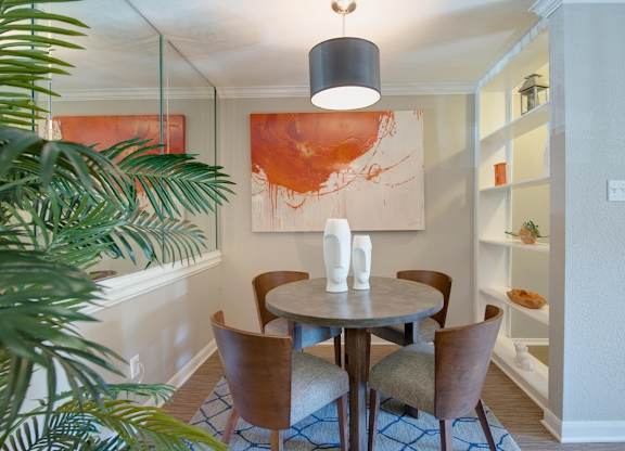 a dining room with built-in shelving and model furnishings in a home at Hudson at Westchase Apartments
