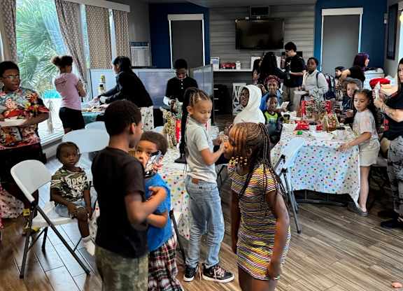 A group of people are gathered around a table in a room.