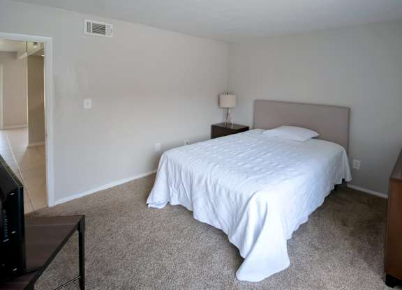 a carpeted bedroom with furnishings in the model at Winford Place Apartments
