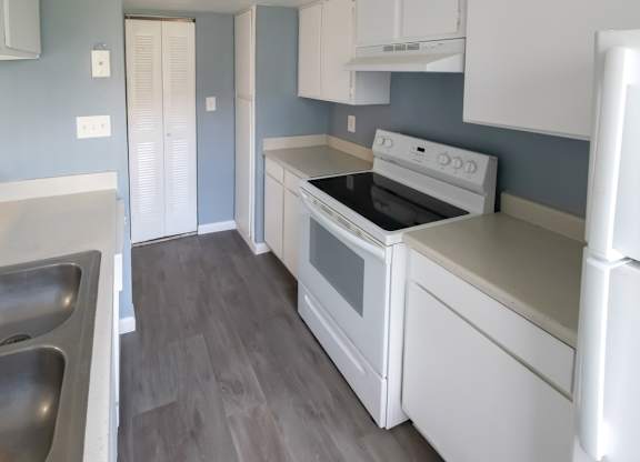 a kitchen with white appliances and a double stainless steel sink