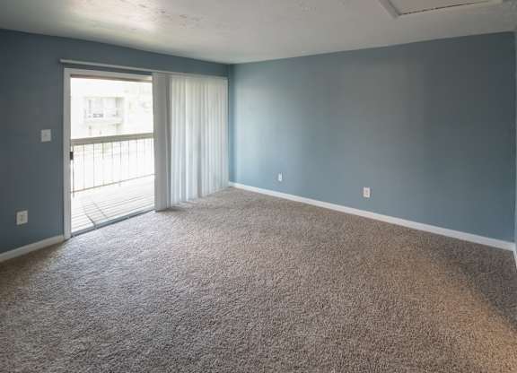 a bedroom with carpeting and sliding glass doors to a private deck at Winford Place