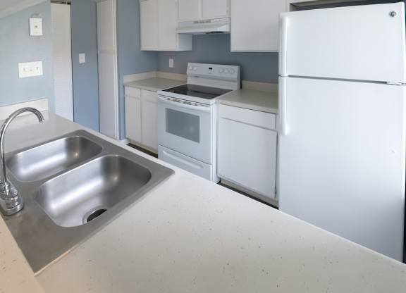 a kitchen with white appliances and cabinets and a stainless steel double sink