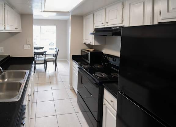 a Winford Place kitchen with black appliances and white cabinets
