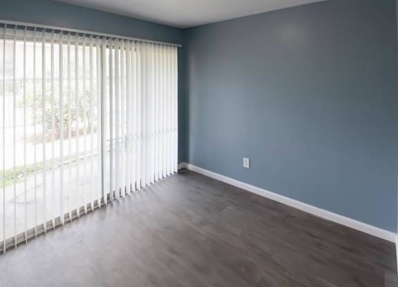 a living room with wood-style flooring and a sliding glass door to a private patio
