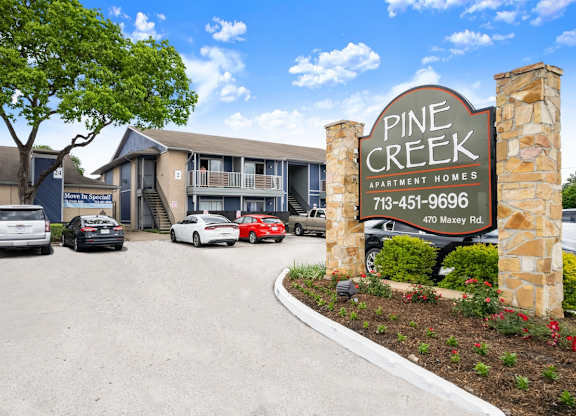 the entrance and monument sign at Pine Creek Apartments for rent in Houston, TX