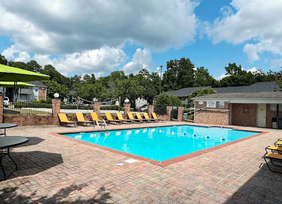 a swimming pool with yellow lounge chairs around it at Ascot Place Apartments, Alabama, 35235