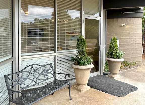 a bench and potted plants in front of a building at Spring Lake Cove Apartments, Birmingham, 35215