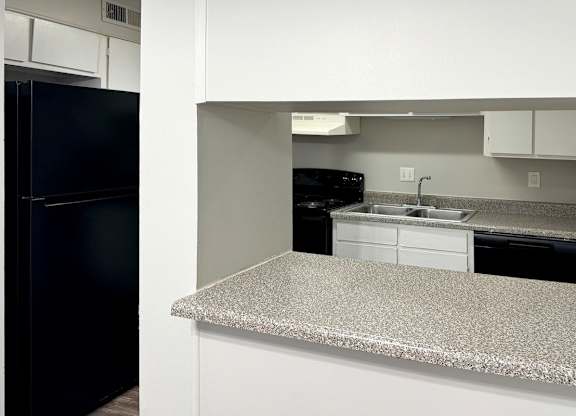 a kitchen with a granite counter top and a black refrigerator at Spring Lake Cove Apartments, Birmingham, AL 