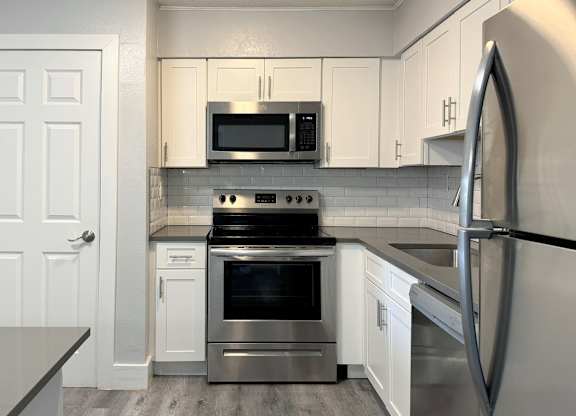 a kitchen with stainless steel appliances and white cabinets at Ascot Place Apartments, Birmingham, AL