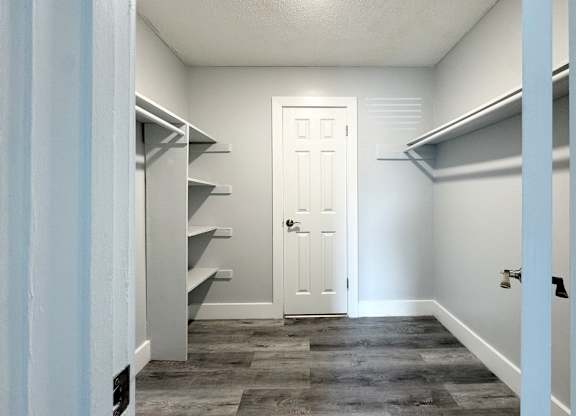 a walk in closet with a white door and a hallway with shelves and a door at Ascot Place Apartments, Birmingham Alabama