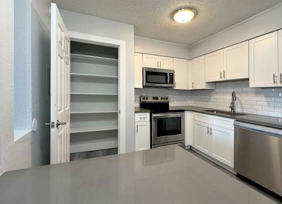 a kitchen with white cabinets and stainless steel appliances at Ascot Place Apartments, Birmingham, 35235 