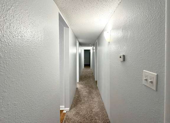 the hallway of a house with a carpeted floor and white walls at Ascot Place Apartments, Birmingham