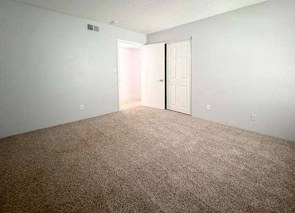 an empty room with a carpeted floor and a white door at Ascot Place Apartments, Alabama