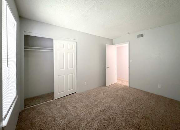 an empty bedroom with a closet and a white door at Ascot Place Apartments, Alabama, 35235