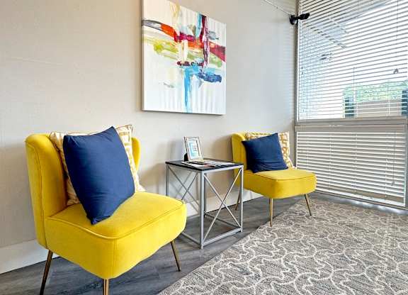 a living room with two yellow chairs and a table and a window at Spring Lake Cove Apartments, Birmingham, AL