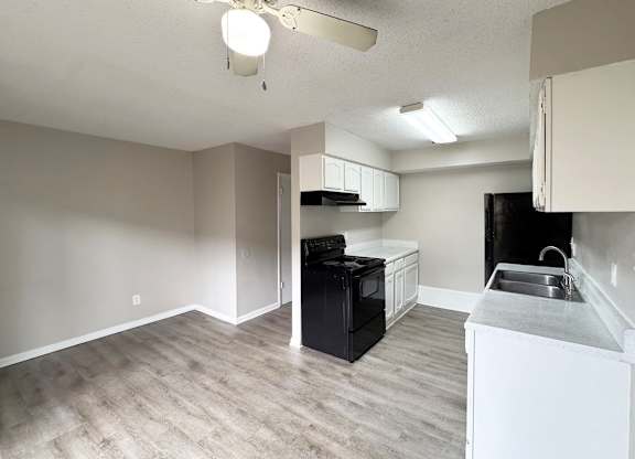 A kitchen with a black oven and white cabinets.