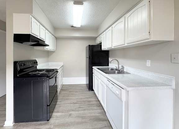 A kitchen with black appliances and white cabinets.