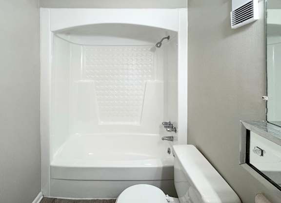 A white bathroom with a toilet, sink, and bathtub.