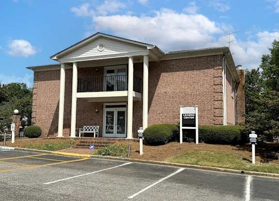 a brick building with a sign in front of a parking lot at Ascot Place Apartments, Birmingham 