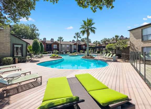 the lush sundeck and pool with lounge chairs at Hudson at Westchase Apartments