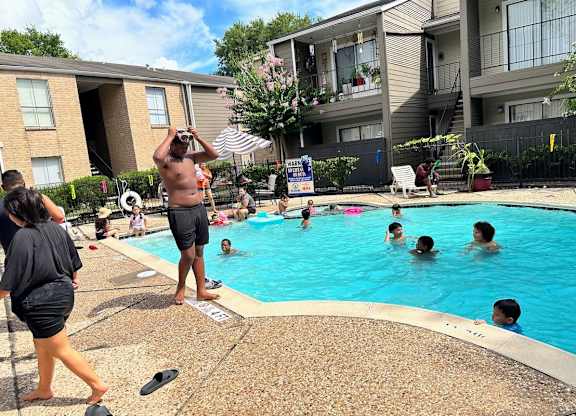 A group of people are enjoying a sunny day at a pool.