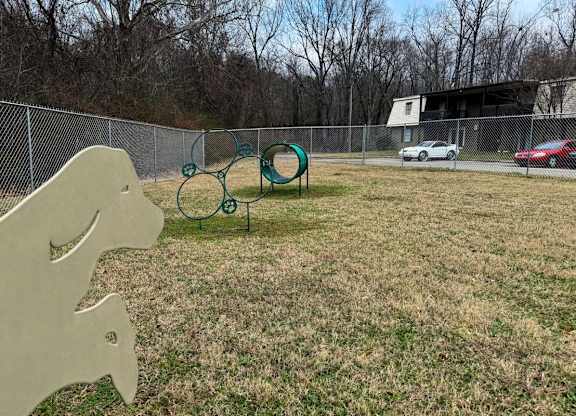 A playground with a slide and a seesaw in a grassy area.