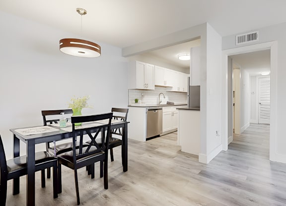 A large kitchen and dining room with wood-style floors and model furnishing at Spring Lake Cove Apartments, Birmingham, AL