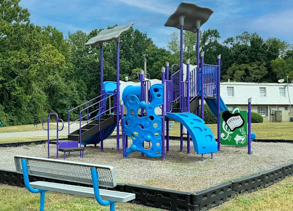 a playground at a park with a blue playset at Spring Lake Cove Apartments, Alabama