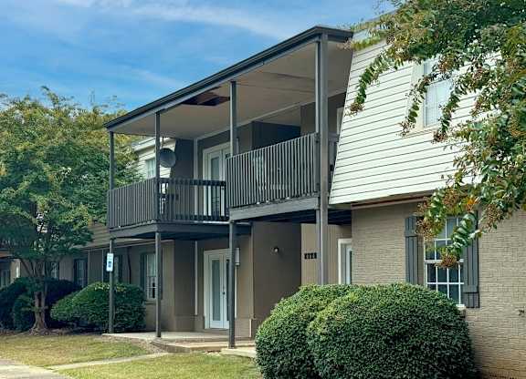 an apartment building with a balcony and trees at Spring Lake Cove Apartments, Birmingham