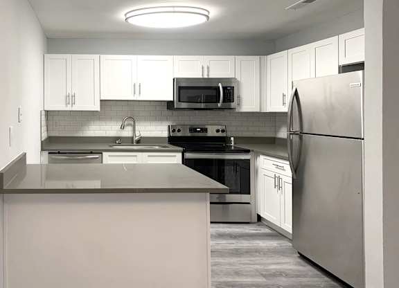 a kitchen with stainless steel appliances and white cabinets at Spring Lake Cove Apartments, Birmingham