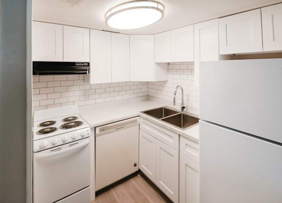 A Waterview Crossing Apartment kitchen with white appliances, tile, and cabinets