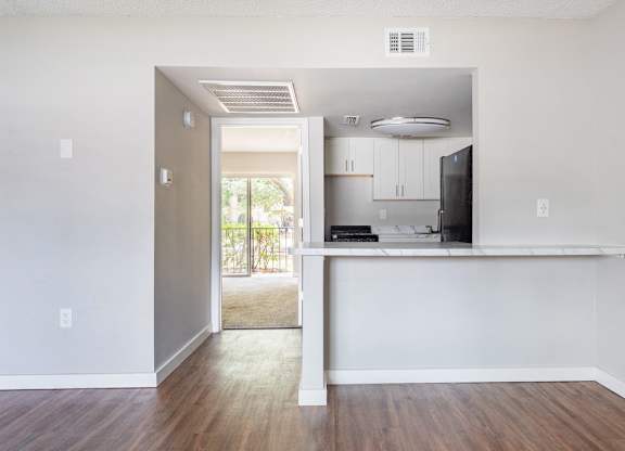 a living room with wood-style flooring and a kitchen with black appliances at Waterview Crossing