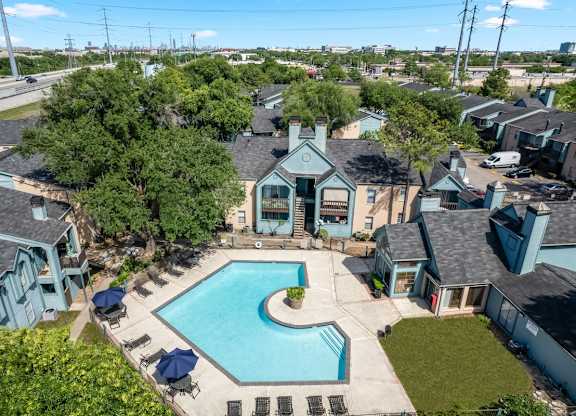an aerial view of the clubhouse, pool, and residences at Waters at Westchase Apartments in Houston