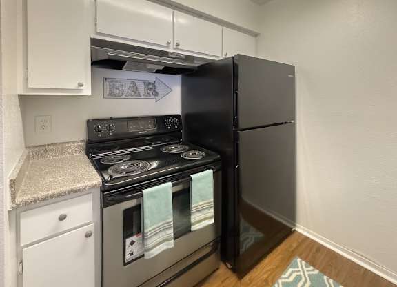 a kitchen with stainless steel appliance stove and a black refrigerator