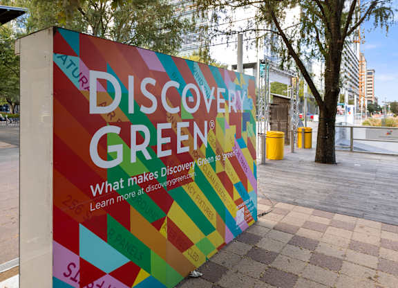 A colorful advertisement for Discover Green is displayed in an outdoor setting.